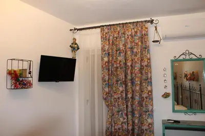 a room with a curtain and a television on a wall at cocciu d'amuri in Caccamo