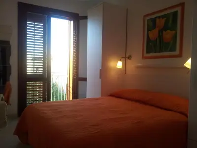a bedroom with a bed and a window with flowers at Essenzamare in San Vito lo Capo