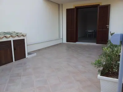 an empty room with a door and a tile floor at Essenzamare in San Vito lo Capo