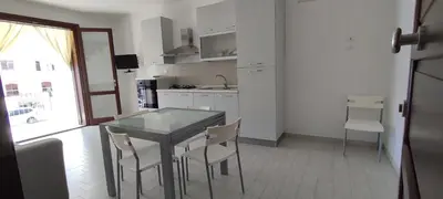 a kitchen with a table and chairs and a window at Essenzamare in San Vito lo Capo