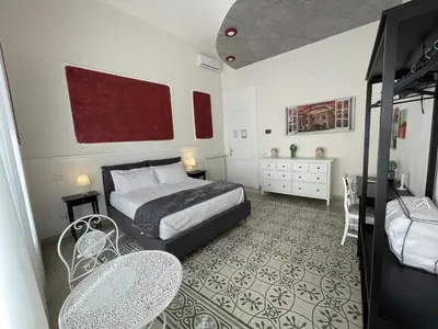 a bedroom with a bed and a table and chairs at Liberty Palace in Palermo