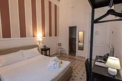 a bedroom with a bed with two stuffed animals on it at Liberty Palace in Palermo