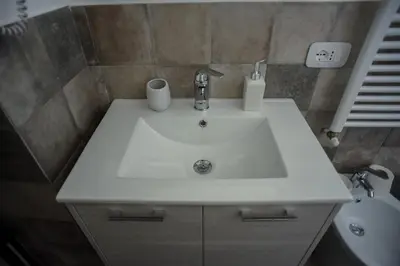 a bathroom sink with two cups on top of it at Rooms 19 B&B in Palermo