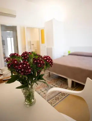 a vase filled with red flowers sitting on a table at Rooms 19 B&B in Palermo