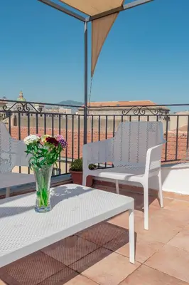 a vase of flowers sitting on a table on a balcony at Rooms 19 B&B in Palermo