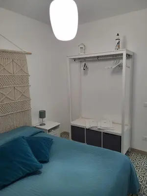 a bedroom with a blue bed and a lamp at DORIDE Appartamento sulla spiaggia in Balestrate