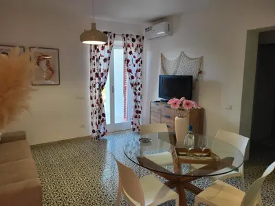 a living room with a glass table and chairs at DORIDE Appartamento sulla spiaggia in Balestrate