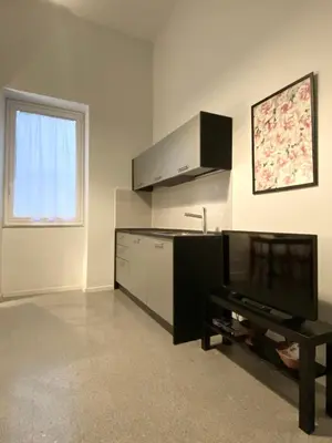 a kitchen with a tv and a table in a room at Da Nelly al Politeama in Palermo