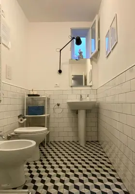 a white bathroom with a toilet and a sink at Da Nelly al Politeama in Palermo