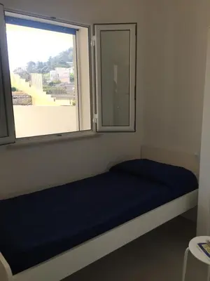 a bed in a room with a large window at Alcamo Marina Residence in Alcamo Marina