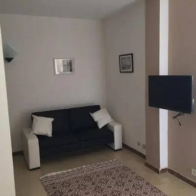a living room with a black couch and a flat screen tv at George House Mondello 32 in Mondello
