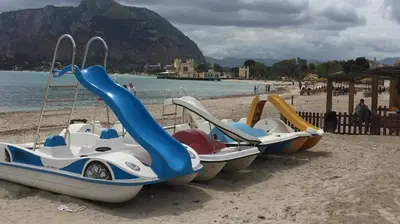 a row of boats sitting on the beach at George House Mondello 32 in Mondello