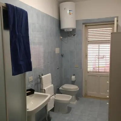 a bathroom with a white toilet and a sink at George House Mondello 34 in Mondello