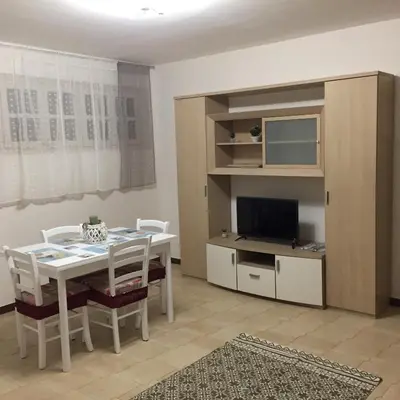 a dining room with a white table and a tv at George House Mondello 34 in Mondello