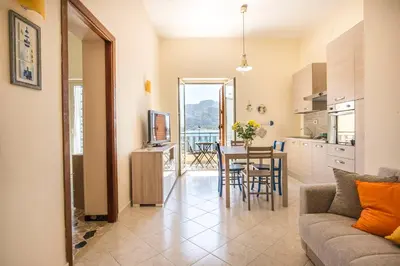 a living room with a couch and a table with chairs at Casetta Vista Mare in Piazza a Mondello by Wonderful Italy in Palermo