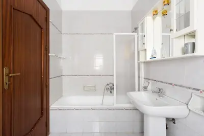 a white bathroom with a tub and a sink at Casetta Vista Mare in Piazza a Mondello by Wonderful Italy in Palermo
