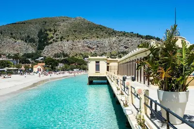 a view of a beach with a pier and buildings at Casetta Vista Mare in Piazza a Mondello by Wonderful Italy in Palermo