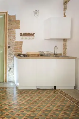 a kitchen with white cabinets and a sink at Stylish Home in Front of Casa Professa by Wonderful Italy in Palermo