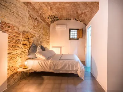 a bedroom with a bed in a brick wall at Stylish Home in Front of Casa Professa by Wonderful Italy in Palermo