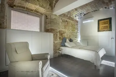 a bedroom with a bed and a chair at Stylish Home in Front of Casa Professa by Wonderful Italy in Palermo