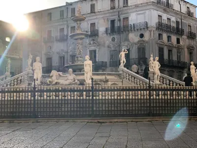 a fountain in front of a building with statues at Apartment Rua Formaggi in Palermo