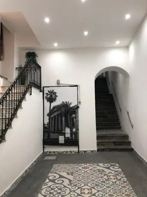 an empty hallway with stairs and a door with a rug at Apartment Rua Formaggi in Palermo