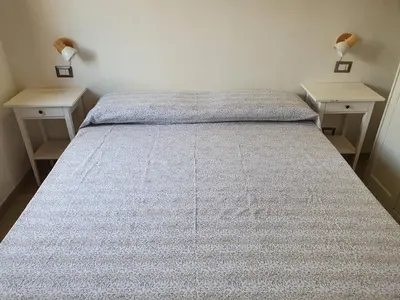 a bed in a room with two nightstands and two tables at Villa Lindi in Castellammare del Golfo
