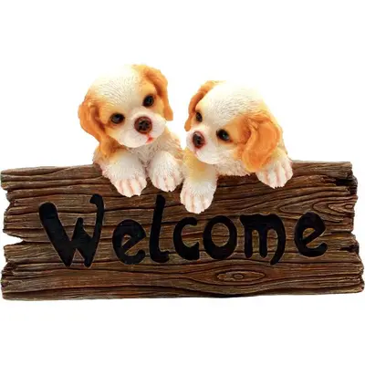 two puppies sitting on a sign with the word welcome at OrangeBalestrate in Balestrate