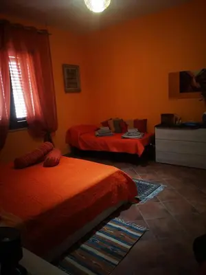 two beds in a room with orange walls at OrangeBalestrate in Balestrate