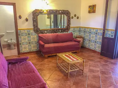a living room with a couch and a mirror at VILLA VENERE con vista sul mare in San Vito lo Capo