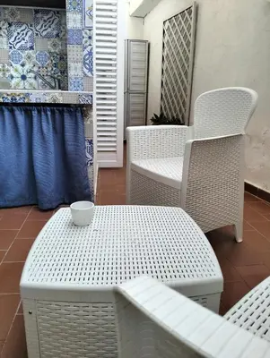 a table and chairs with a cup on top of it at Casa Vacanze Mondello Mare Piscina ALBAMAOR in Mondello
