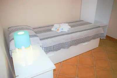 a small room with a bed with a light on it at tramonto blu in Palermo