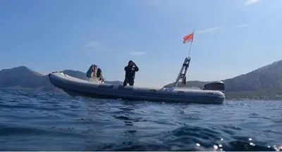 two people and a dog on a boat in the water at Bed Ponente in Isola delle Femmine