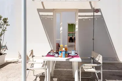 a white table and chairs on a patio at Vitorno Residence in San Vito lo Capo