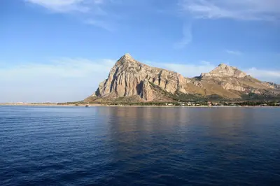 a mountain in the middle of a large body of water at Vitorno Residence in San Vito lo Capo