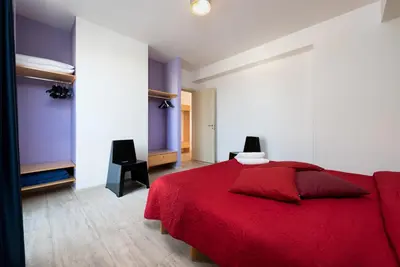 a bedroom with a red bed with a red blanket at Vitorno Residence in San Vito lo Capo