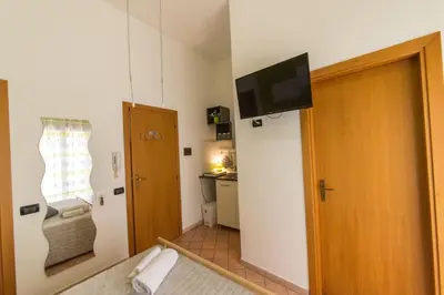 a room with a door and a television on a wall at 'A Cumerdia - Casa Vacanze in Castellammare del Golfo