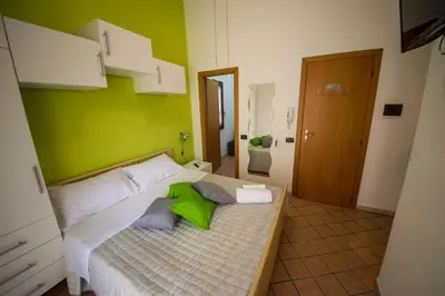 a bedroom with a bed with a green wall at 'A Cumerdia - Casa Vacanze in Castellammare del Golfo