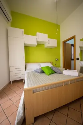 a large bed in a room with a green wall at 'A Cumerdia - Casa Vacanze in Castellammare del Golfo