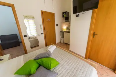 a room with a bed with green pillows on it at 'A Cumerdia - Casa Vacanze in Castellammare del Golfo