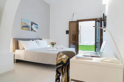 a bedroom with a bed and a desk with a laptop at Baglio La Riserva in Scopello
