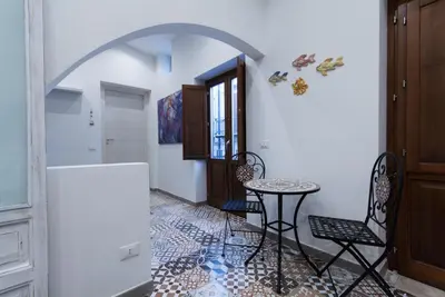 a hallway with a table and chairs in a room at Casa Leonardo e Romeo in Castellammare del Golfo