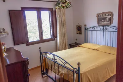 a bedroom with a bed and a window at Villa Verde con vista sul mare in San Vito lo Capo