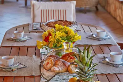 a table with a tray of bread and flowers on it at Villa Sansone in Altavilla Milicia