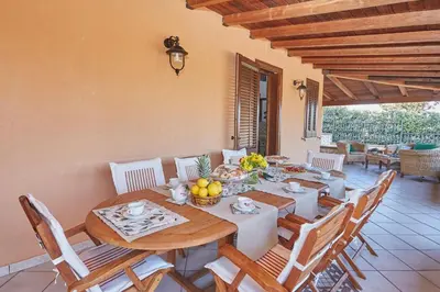 a dining room with a wooden table and chairs at Villa Sansone in Altavilla Milicia