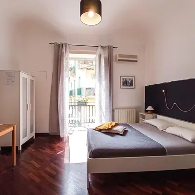 a bedroom with a bed and a large window at B&B Bandiera 77 in Palermo