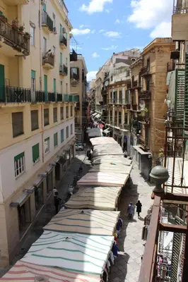 a street with many umbrellas on the sides of buildings at B&B Bandiera 77 in Palermo
