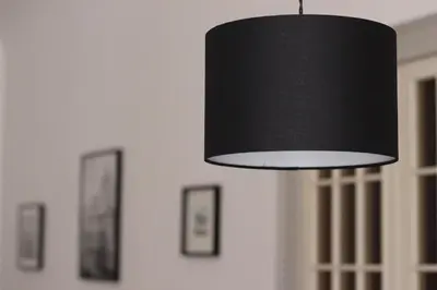 a black lamp hanging from a wall with pictures at B&B Bandiera 77 in Palermo
