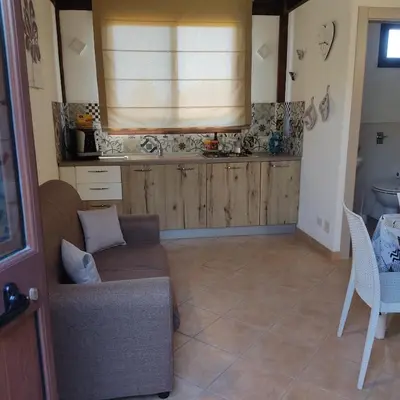 a living room with a couch and a table and a window at Baglio cracchiolo da tuzzo Villa Ulivo in San Vito lo Capo