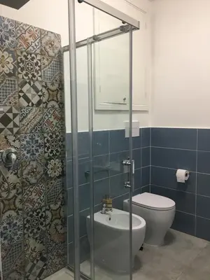 a bathroom with a toilet and a glass shower at Casa Nicuzza in Palermo